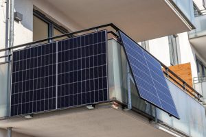 Solarpanels sind an der Brüstung eines modernen Balkons montiert.