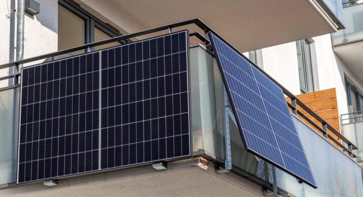 Solarpanels sind an der Brüstung eines modernen Balkons montiert.